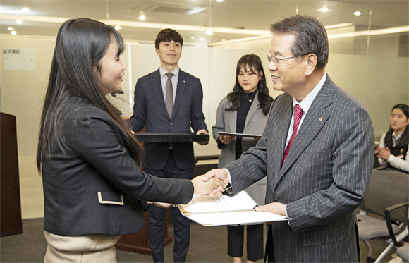 문암 장학문화재단 권혁운(오른쪽) 이사장이 지난해 12월 제4회 장학금 전달식에서 학생에게 장학금 증서를 전달하며 격려하고 있다. 올해는 코로나19 사회적 거리두기 시행으로 비대면으로 장학금 전달식을 진행한다. 문암장학문화재단 제공