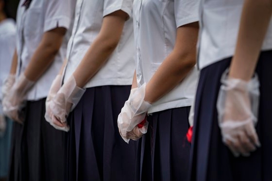 일본 후쿠오카 시립 중학교 69곳을 조사한 결과 불합리한 복장 및 두발 규정 등이 지적됐다. 사진은 일본 학생들이 교복을 입은 채 코로나 19(신종 코로나 바이러스 감염증) 방지를 위해 위생 장갑을 낀 모습/EPA=연합