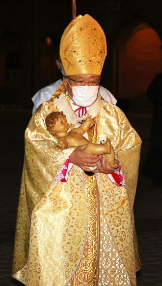 아기 예수 구유에 안치하는 염수정 추기경