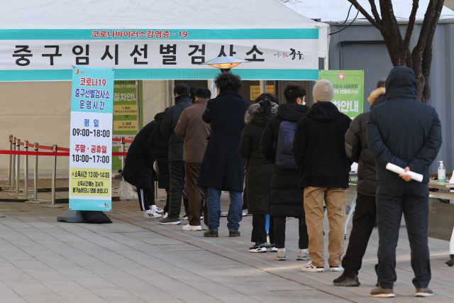 신규 확진자가 1200명대를 기록한 25일 오후 서울광장에 마련된 임시선별진료소에서 시민들이 검사를 받기 위해 줄을 서 있다/연합뉴스