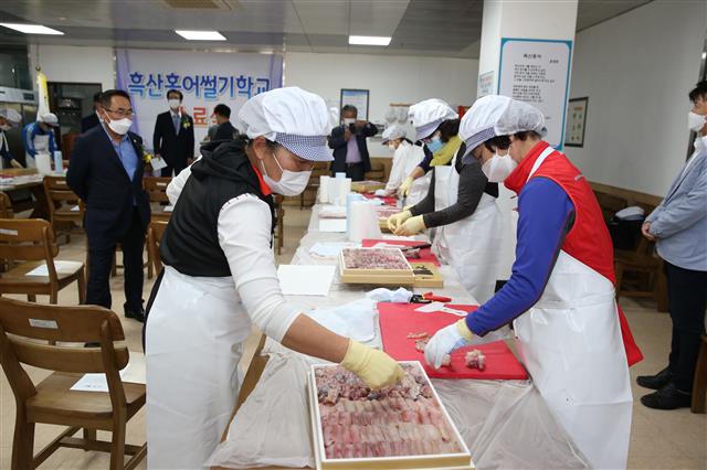 전남 신안에 있는 ‘흑산홍어 썰기 학교’에서 학생들이 홍어를 다듬는 실습을 하고 있다.<br>신안군 제공