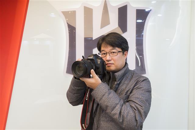 프로야구 kt 위즈 전속 사진작가 지용현씨가 지난 22일 수원kt위즈파크에서 서울신문과 인터뷰하며 자신의 카메라로 사진 찍는 포즈를 취하고 있다.