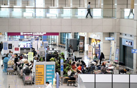 영국발 변이 코로나19 바이러스가 국내에서 확인되는 등 코로나19 확산이 계속되고 있는 28일 오전 인천국제공항 1터미널 입국장에서 베트남 입국객 등이 지정장소에서 대기하고 있다. 2020.12.28  연합뉴스