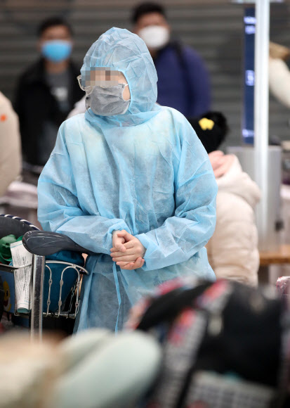 영국발 변이 코로나19 바이러스가 국내에서 확인되는 등 코로나19 확산이 계속되고 있는 28일 오전 인천국제공항 1터미널 입국장에서 방호복을 입은 해외 입국객이 대기하고 있다. 2020.12.28  연합뉴스
