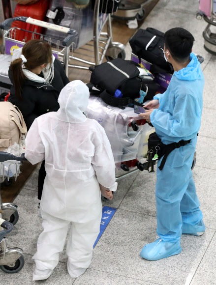 영국발 변이 코로나19 바이러스가 국내에서 확인되는 등 코로나19 확산이 계속되고 있는 28일 오전 인천국제공항 1터미널 입국장에서 방호복을 입은 베트남 입국객들이 대기하고 있다. 2020.12.28  연합뉴스