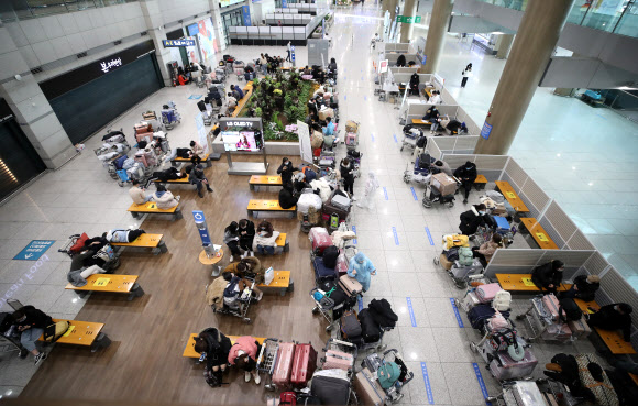 영국발 변이 코로나19 바이러스가 국내에서 확인되는 등 코로나19 확산이 계속되고 있는 28일 오전 인천국제공항 1터미널 입국장에서 베트남 입국객 등이 지정장소에서 대기하고 있다. 2020.12.28  연합뉴스
