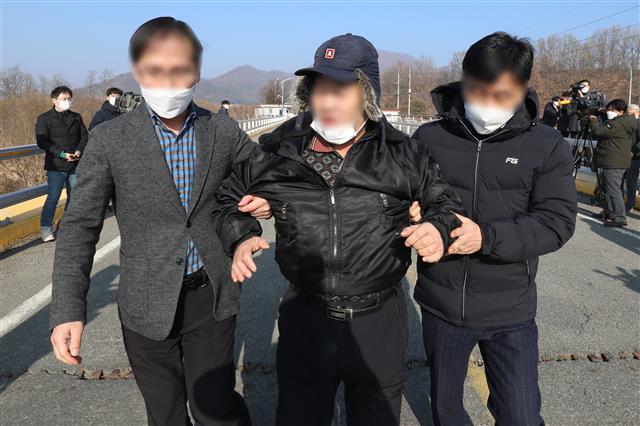 28일 오전 서울 동부구치소에서 신종 코로나바이러스 감염증(코로나19) 확진 판정을 받은 수용자를 태운 버스가 경북 청송군 경북북부 제2교도소로 출발했다는 소식이 전해진 가운데 자신을 청송군 주민이라고 밝힌 한 남성이 확진자 수용에 반대하며 도로를 가로막고 누워 현장에 배치된 경찰이 설득하고 있다. 2020.12.28 뉴스1