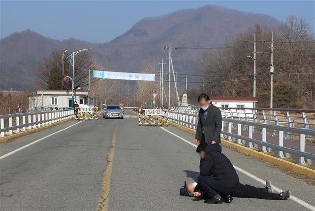 28일 오전 서울 동부구치소에서 신종 코로나바이러스 감염증(코로나19) 확진 판정을 받은 수용자를 태운 버스가 경북 청송군 경북북부 제2교도소로 출발했다는 소식이 전해진 가운데 자신을 청송군 주민이라고 밝힌 한 남성이 확진자 수용에 반대하며 도로를 가로막고 누워 현장에 배치된 경찰이 설득하고 있다. 2020.12.28 뉴스1
