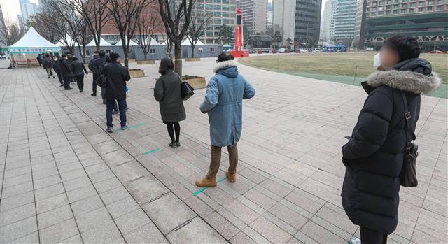 29일 오전 서울시청 앞 광장에 마련된 임시 선별진료소에서 시민들이 코로나19 검사를 하기 위해 줄을 서있다. 2020.12.29 뉴스1