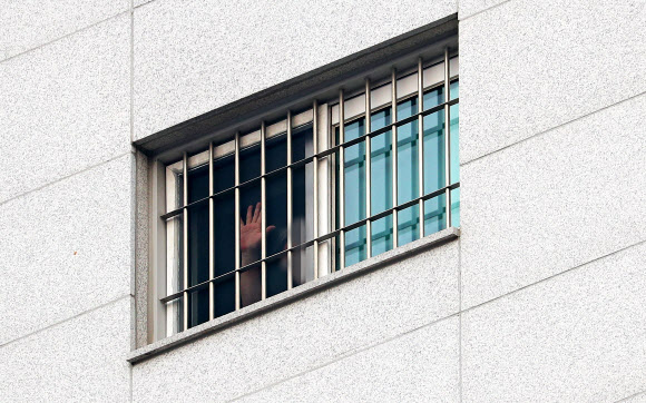 코로나19 집단 감염으로 확진자 750여명이 발생한 서울 송파구 동부구치소에서 29일 오전 한 수용자가 손을 흔들고 있다. 어제 동부구치소에서 233명의 확진자가 추가돼 지금까지 이곳에서만 총 757명이 감염됐다. 2020.12.29  연합뉴스