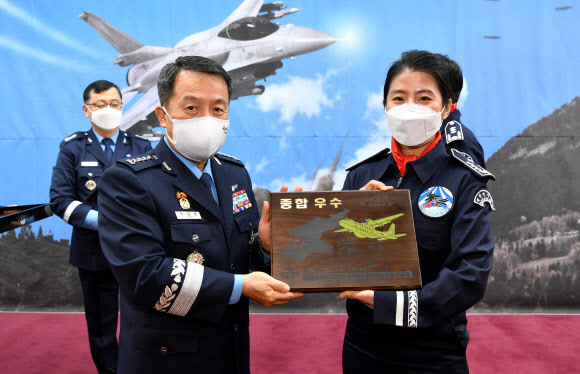 이성용 공군참모총장(왼쪽)이 29일 충남 계룡대 공군본부에서 열린 ‘2020년 보라매 공중사격대회 시상식’에서 공중기동기 분야 공중투하 부문 최우수 조종사로 선정된 이세리 소령에게 기념패를 수여한 뒤 기념촬영을 하고 있다. 2020.12.29  공군 제공