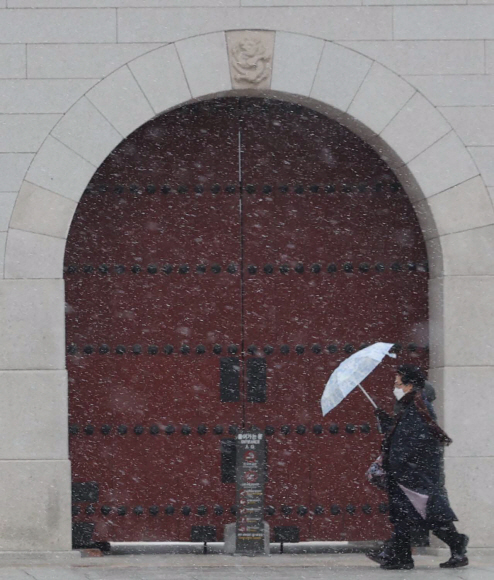 전국에 눈과 비가 내린 29일 서울 종로구 광화문 앞에서 우산을 쓴 시민들이 걸어가고 있다. 기상청은 이날 오후 9시를 기해 서울 전역에 한파주의보를 발령했다. 오장환 기자 5zzang@seoul.co.kr