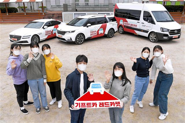 충남 홍성고 헌혈 동아리 학생들이 ‘기프트카 레드카펫’ 헌혈 캠페인 차량을 배경으로 기념사진을 찍고 있다. 현대자동차그룹 제공