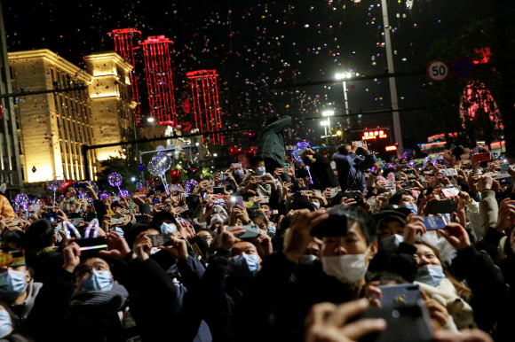 코로나19 감염병의 진원지인 중국 우한 시민들이 31일 새해 전야 행사에 운집해 있다. 마스크를 쓰긴 했지만 한국이 5명 이상 모이지 않게 하는 등 강력한 사회적 거리 두기를 시행하는 것과 대조를 이룬다. 우한 로이터 연합뉴스 