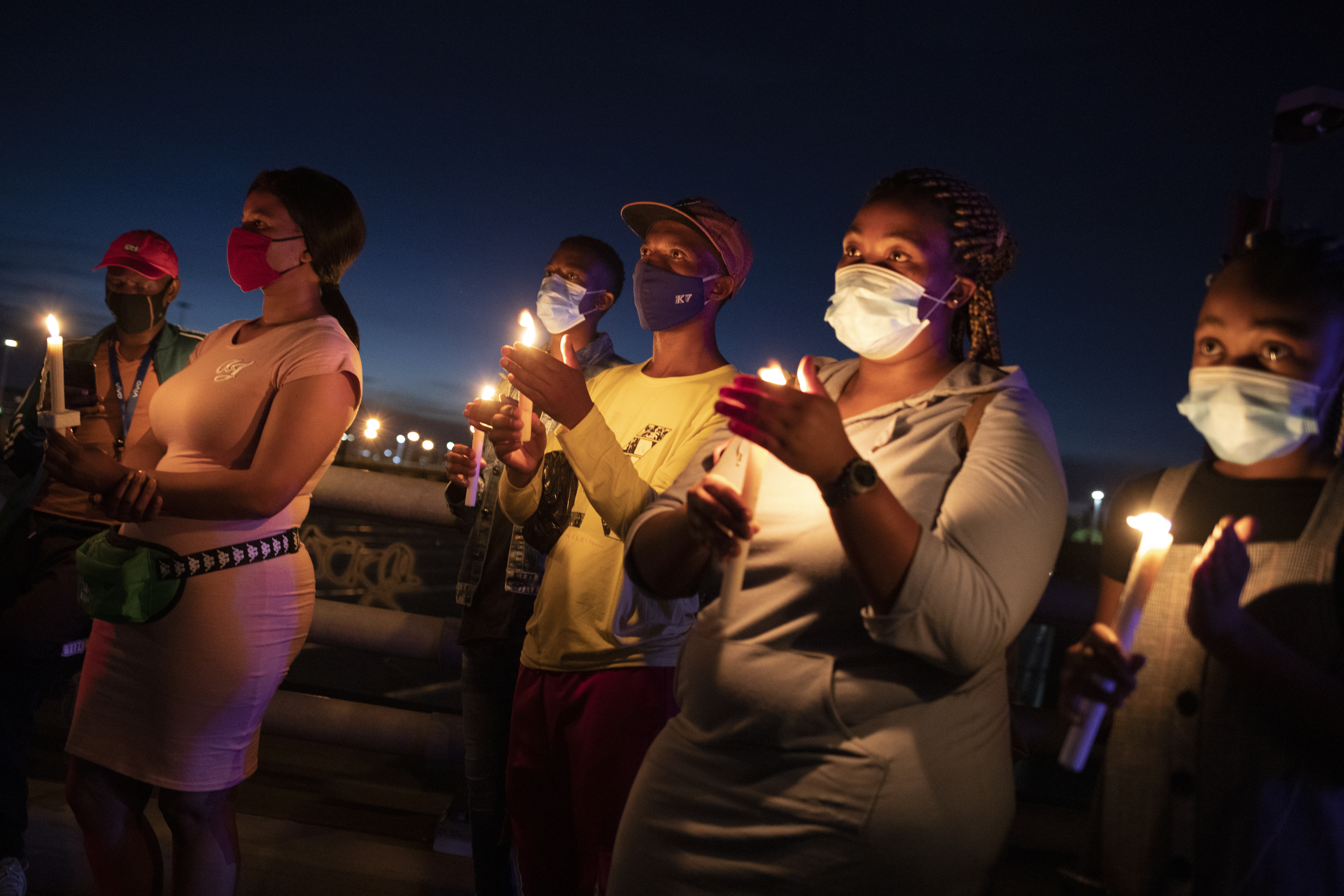 남아프리카공화국 요하네스버그에서 31일(현지시간) 마스크를 쓴 사람들이 올해 코로나19 희생자를 기리는 촛불을 켜고 있다. 요하네스버그 EPA 연합뉴스 