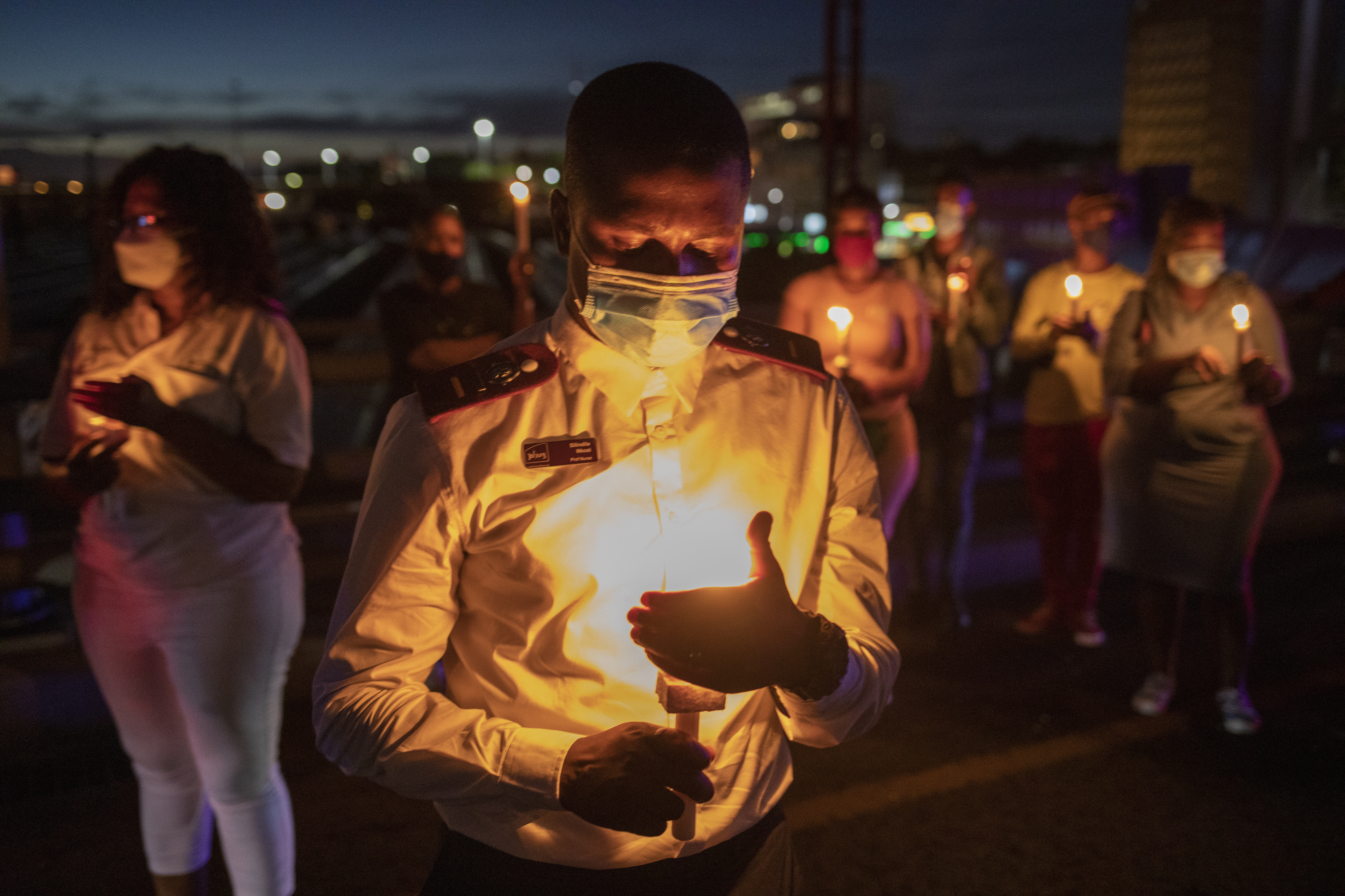 ▲ 남아프리카공화국 요하네스버그에서 31일(현지시간) 의료진들이 올해 코로나19 희생자를 기리는 촛불을 켜고 있다. 요하네스버그 EPA 연합뉴스