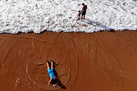 사람들이 1일(현지시간) 포르투갈 리스본 외곽 카스카이스 카르카벨로스 해변에서 새해 첫 목욕을 즐기고 있다. EPA 연합뉴스