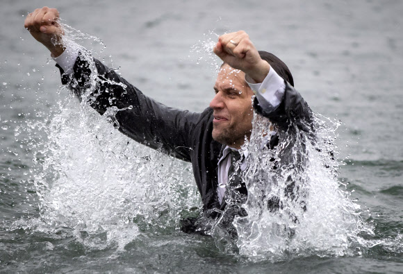 제이슨 루드는 1일(현지시간) 캐나다 브리티시컬럼비아주 밴쿠버의 잉글리시 베이에서 열린 새해맞이 북극곰 수영대회에서 30년차 참가를 축하하며 양복과 넥타이를 매고 물 속으로 뛰어 들었다. AP 연합뉴스