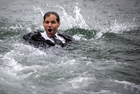 제이슨 루드는 1일(현지시간) 캐나다 브리티시컬럼비아주 밴쿠버의 잉글리시 베이에서 열린 새해맞이 북극곰 수영대회에서 30년차 참가를 축하하며 양복과 넥타이를 매고 물 속으로 뛰어 들었다. AP 연합뉴스