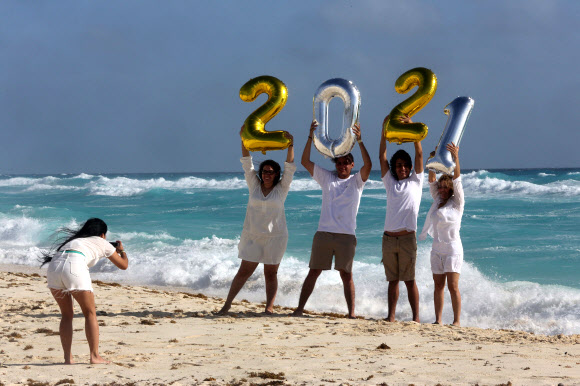 관광객들이 1일(현지시간) 멕시코 퀸타나 루 주의 칸쿤 리조트에서 ‘2021년’ 풍선을 들고 포즈를 취하고 있다. EPA 연합뉴스