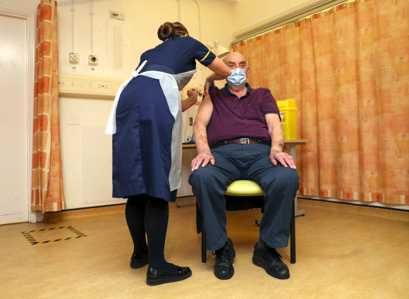 82세의 브라이언 핀커가 4일 영국 옥스퍼드의 처칠 병원에서 간호사로부터 아스트라제네카의 코로나19 백신을 세계 최초로 맞고 있다. 연합뉴스.