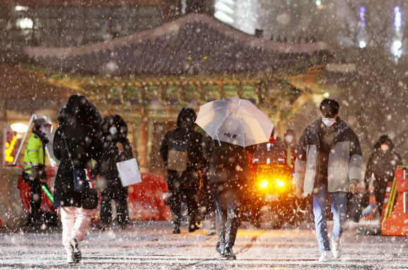 서울 전역에 대설주의보가 발효된 6일 저녁 서울 광화문역 인근에서 시민들이 퇴근길을 재촉하고 있다. 2021.1.6  연합뉴스