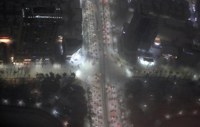 서울 전역에 대설주의보가 발효된 30일 오후 서울 송파구 서울스카이에서 바라본 서울 도심에 눈이 쌓여 차량들이 서행하고 있다. 2021.1.6 뉴스1