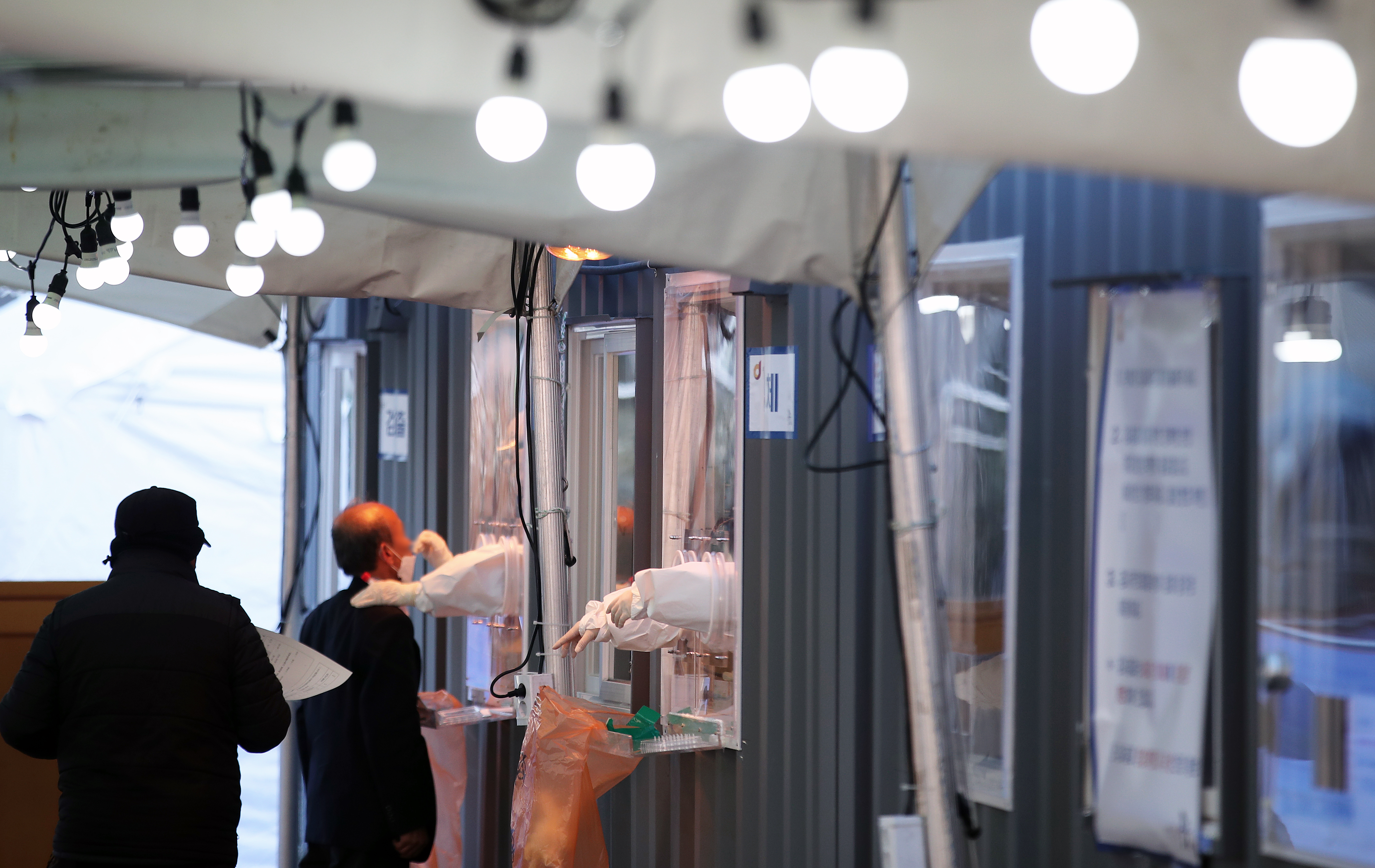 ‘북극한파’가 한반도를 덮친 6일 오전 서울 중구 서울역에 마련된 신종 코로나 바이러스 감염증(코로나19) 임시 선별진료소에서 시민들이 줄 지어 검사를 받고 있다. 2021.1.6 뉴스1
