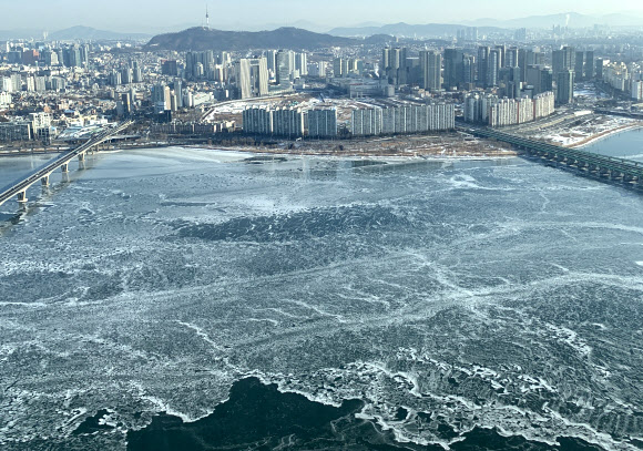 9일 서울 영등포구 여의도 63빌딩에서 바라본 한강이 얼어 있다.  기상청은 이날 이번 겨울 들어 한강 첫 결빙이 관측됐다고 밝혔다. 한강의 결빙 관측은 노량진 한강대교 부근을 기준으로 한다. 한강대교 두 번째와 네 번째 교각 상류 100m 부근의 띠 모양 구역이 완전히 얼음으로 덮여 강물이 보이지 않을 때 결빙으로 판단한다. 2021.1.9 연합뉴스