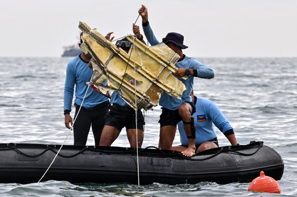 여객기 추락사고가 발생한 인도네시아 자카르타 앞바다에서 10일 수색대원들이 추락 여객기의 일부로 추정되는 파편을 들어올리고 있다. 자카르타 AFP 연합뉴스