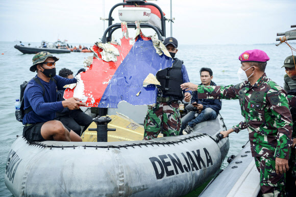 인도네시아 해군 대원들이 10일(현지시간) 자카르타 해안에서 추락한 스리위자야항공 SJ182편 여객기 잔해들을 수거하고 있다.  로이터 연합뉴스
