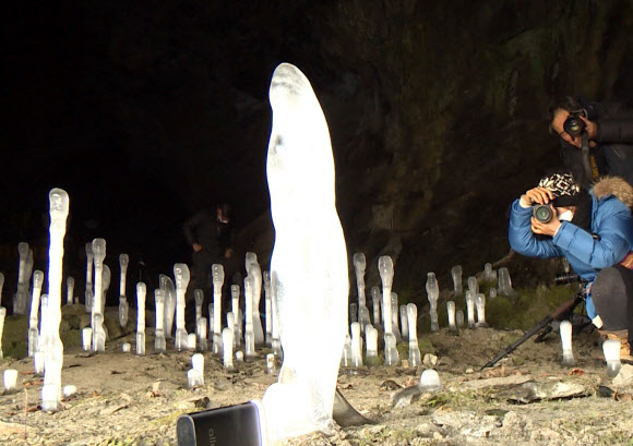 최근 영하 20도 안팎의 북극발 동장군이 기승을 부린 충북 제천시 덕산면 보덕굴에 ‘역(逆)고드름’ 100여 개가 만들어졌다고 14일 보덕굴 측이 전했다. 사진은 땅에서 만들어진 고드름 촬영하는 사진작가들. 2021.1.14 연합뉴스