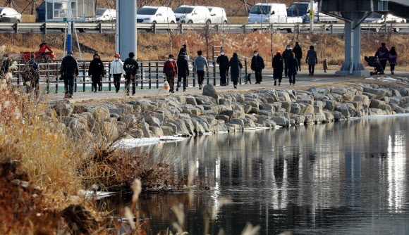 한파가 물러난 14일 오후 서울 중랑구 이화교 인근 공원을 찾은 시민들이 산책하고 있다. 2021.1.14  연합뉴스