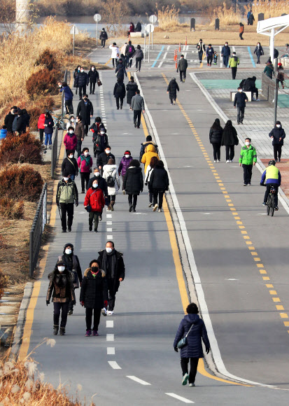 한파가 물러난 14일 오후 서울 중랑구 이화교 인근 공원을 찾은 시민들이 산책하고 있다. 2021.1.14  연합뉴스