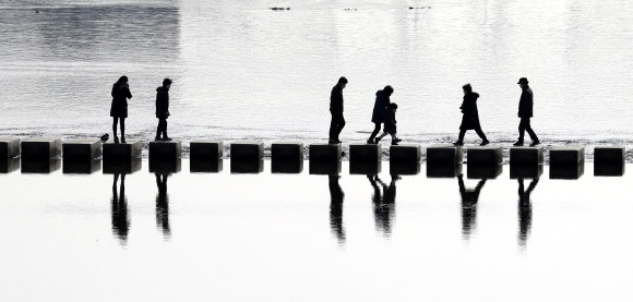 기온이 풀리면서 낮 최고 기온이 영상 7도까지 올라간 14일 서울 중랑천에서 시민들이 나와 산책하며 징검다리를 건너고 있다. 2021.1.14  연합뉴스