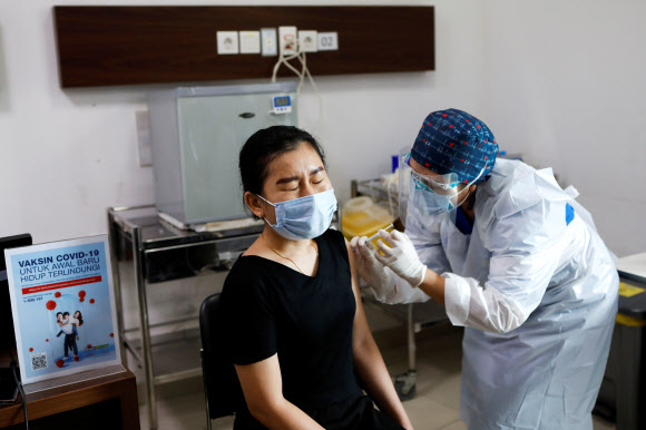 인도네시아 자카르타의 한 병원에서 14일 한 젊은 여성이 코로나19 백신을 맞고 있다. 자카르타 로이터 연합뉴스