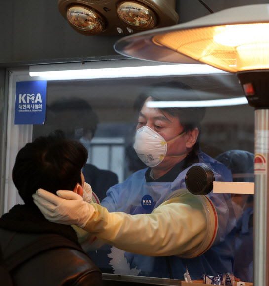 국민의당 안철수 대표가 15일 서울광장에 마련된 임시 선별검사소에서 의료 자원봉사에 나서 검체를 채취하고 있다.  2021.1.15 국회사진기자단