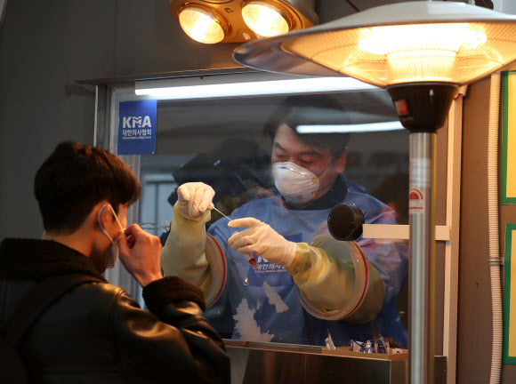 국민의당 안철수 대표가 15일 서울광장에 마련된 임시 선별검사소에서 의료 자원봉사에 나서 검체를 채취하고 있다.  2021.1.15    국회사진기자단