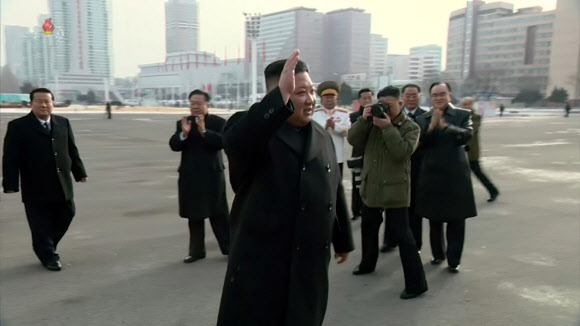 김정은 국무위원장이 지난 14일 평양 4?25문화회관 앞에서 노동당 제8차 대회 대표자들과 기념사진을 찍었다고 조선중앙통신이 15일 보도했다. 김 위원장은 이날 검은색 리무진을 타고 등장한 뒤 손을 들어 대표자들에게 인사했다.  2021.1.15  조선중앙TV 화면