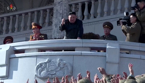 김정은 북한 국무위원장이 16일 제8차 당대회 기념 열병식 참가자들과 김일성광장에서 기념사진을 촬영했다고 17일 조선중앙TV가 전했다. 사진은 김 위원장이 열병식 참가자들을 향해 주먹을 불끈 쥐어 올리며 격려하는 모습. 2021.1.17  조선중앙TV 화면 캡처