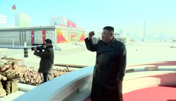 김정은 북한 국무위원장이 16일 제8차 당대회 기념 열병식 참가자들과 김일성광장에서 기념사진을 촬영했다고 17일 조선중앙TV가 전했다. 사진은 김 위원장이 열병식 참가자들을 향해 주먹을 불끈 쥐어 올리며 격려하는 모습.  2021.1.17  조선중앙TV 화면 캡처