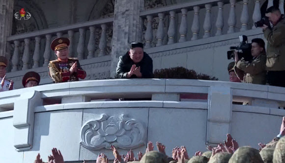 김정은 북한 국무위원장이 16일 제8차 당대회 기념 열병식 참가자들과 김일성광장에서 기념사진을 촬영했다고 17일 조선중앙TV가 전했다. 사진은 김 위원장이 주석단에서 참가자들을 내려다보며 인사하는 모습. 2021.1.17  조선중앙TV 화면 캡처
