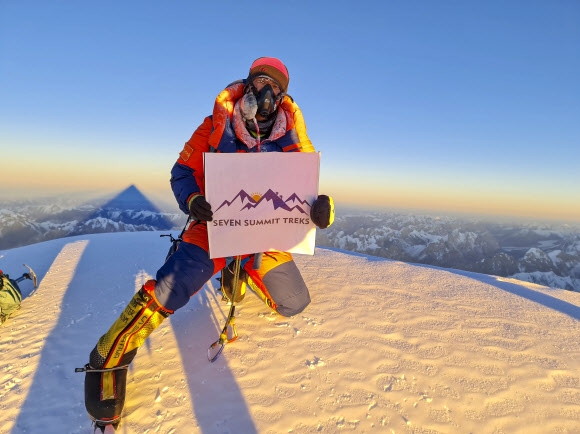 세계 최초로 겨울철 K2 등정에 섣공한 네팔 셰르파 등반대의 소나 셰르파가 16일(현지시간) 정상에서 네팔 트레킹 단체 ‘세븐 서밋 트렉스’ 휘장을 들고 포즈를 취하고 있다. 세븐 서밋 트렉스 제공 EPA 연합뉴스 