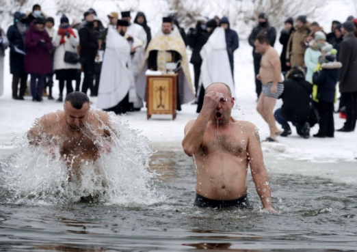 Men plunge into the icy waters
