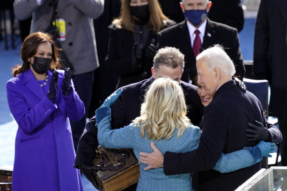 20일(현지시간) 워싱턴DC 국회의사당에서 취임식 도중 조 바이든 대통령과 가족들이 포옹을 나누고 있다. 옆에서 카멀라 해리스 부통령이 박수를 보내고 있다. AP