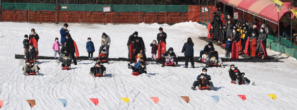 전국 대부분 지역의 기온이 영상권으로 올라간 24일 경기도 과천시 서울랜드 눈썰매장을 찾은 시민들이 썰매를 타고 있다. 2021.1.24 오장환 기자 5zzang@seoul.co.kr