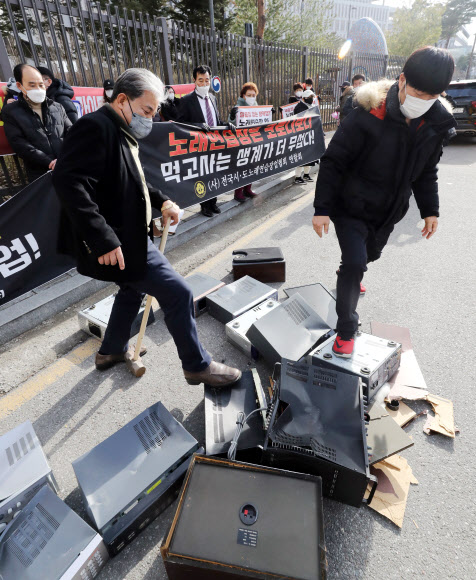 전국 시·도 노래연습장업협회 관계자들이 25일 오후 세종시 정부세종청사 보건복지부 앞에서 코로나19 확산 방지를 위한 방역조치 완화를 촉구하며 노래방 기계를 부수고 있다. 2021.1.25  연합뉴스