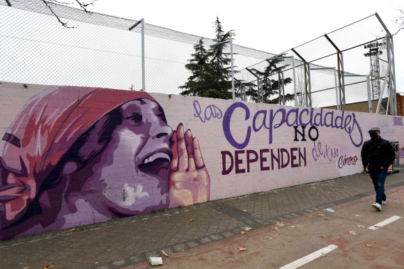 러시아 여성 작가 릴리아 브릭의 초상화가 그려진 스페인 마드리드의 벽화 거리를 25일(현지시간) 한 시민이 지나가고 있다. 이 거리에는 여성 위인 15명의 초상화 그려져 있다.-마드리드 AFP 연합뉴스