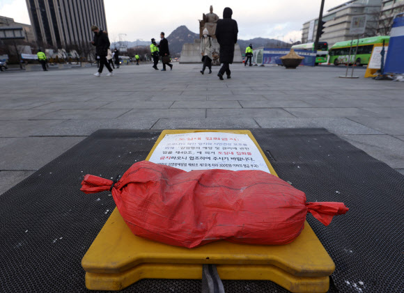 28일 오후 서울 광화문광장에 설치한 집회금지 안내판 위에 강풍에 대비해 모래 주머니가 놓여져 있다. 2021.1.28  연합뉴스