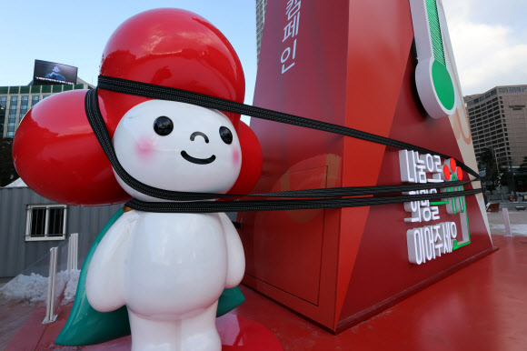 눈이 그치고 강한 바람이 부는 28일 오후 서울광장에 설치된 사랑의 온도탑 옆에 마스코트 조형물이 강풍에 대비해 끈으로 고정되어 있다. 2021.1.28  연합뉴스